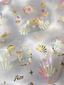 Detail of seashell and starfish nail stickers with golden foil and laser finish