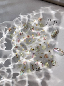 Detail of seashell and starfish nail art stickers with 3D gold embossed textures