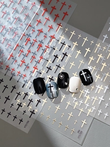 Detail showing relief cross nail stickers in silver, gold, and red on manicured tips