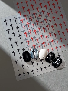 Detailed view of Gothic cross nail art stickers in red, grey, and black on various nails