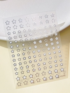 Close-up of sparkling silver star nail art stickers on a transparent backing sheet