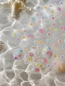 Dettaglio di adesivi per nail art con conchiglie e stelle marine e finitura perlata