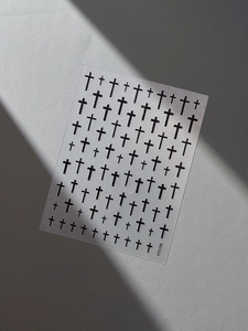Detail of embossed black cross nail stickers on transparent backing with art lighting
