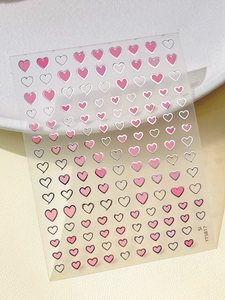 Macro detail of heart-shaped nail art stickers in pink and silver on sheet YT5817