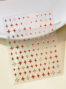 Detailed view of red star nail stickers with metallic gold edges on transparent film