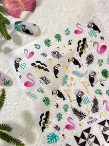 Close-up of tropical nail stickers with flamingo and palm leaf patterns for summer manicure