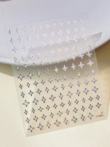 Detail shot of silver metallic star nail art stickers on a textured leather background