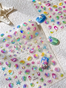 Rainbow shell nail stickers featuring starfish and scallop patterns on textured stone
