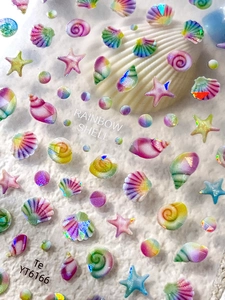 Macro shot of iridescent rainbow shell and starfish nail art stickers with laser finish