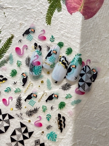 Detail of tropical nail stickers with toucan, flamingo, and monstera leaf patterns