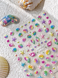 Macro detail of 3D rainbow shell and starfish nail art stickers with embossed texture