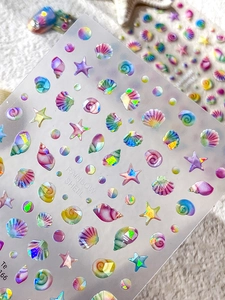 Macro detail of 3D rainbow shell nail stickers with holographic starfish and shell designs