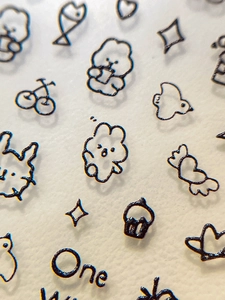 Détails macro d'autocollants nail art minimalistes noirs avec lapins et ours mignons