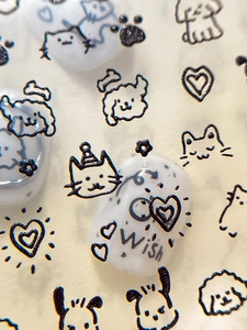 Vue macro détaillée de stickers nail art 3D gaufrés avec motifs de chats et chiens mignons