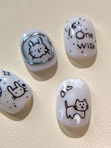 Vue détaillée de faux ongles peints à la main avec lapin, étoiles et texte One Wish