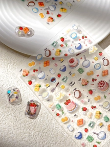 Detail showing hand-drawn strawberry cake and baking themed nail art stickers on nails