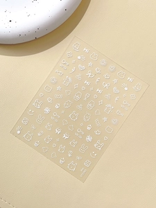 Détail de stickers à ongles de lapins blancs avec motifs de cœurs et étoiles