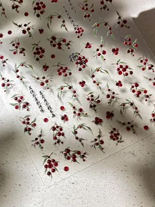 Makro-Detail von roten Beeren und chinesischen Kalligraphie-Nagelstickern auf Textur