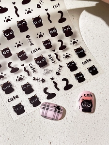 Detail of cute black cat nail art stickers featuring paws, fish bones and cat expressions