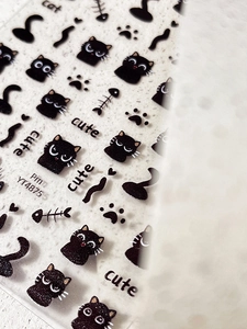 Detail of cute black cat nail art stickers featuring kittens, paw prints and fish bones