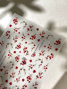 Details von transluzenten Nagelaufklebern mit roten Myrica-Motiven und Kalligrafie