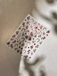 Nahaufnahme von roten Beeren und grünen Blättern auf transparenten Nailart-Aufklebern