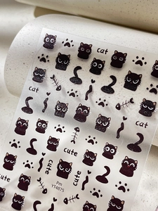 Detail view of black cat nail art stickers with glitter finish and cute paw patterns