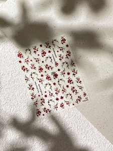 Detailansicht von Nagelaufklebern mit roten Beeren und chinesischer Kalligrafie