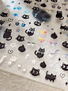 Detailed 3D embossed nail stickers featuring black cartoon cats and laser holographic stars