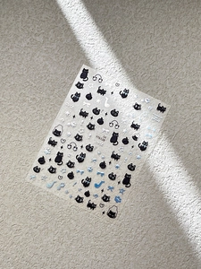 Detail of cute cat nail stickers with bow, star and musical note patterns on beige background