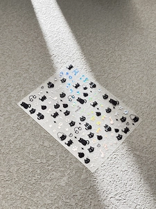 Detail of embossed black cat nail stickers with laser glitter stars and moon accents