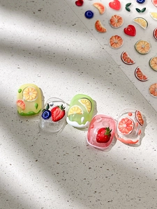 Detail showing 3D embossed fruit nail stickers with realistic strawberry and citrus designs