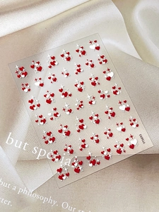 Detail view of heart and star embossed nail art stickers on a silk background