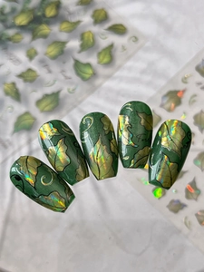 Macro view of forest green cat eye nail stickers with laser aurora leaf patterns