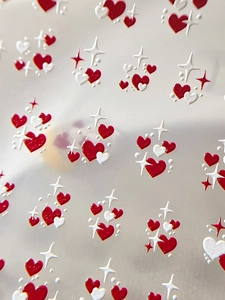 Macro detail of 3D embossed nail stickers featuring red white hearts and stars