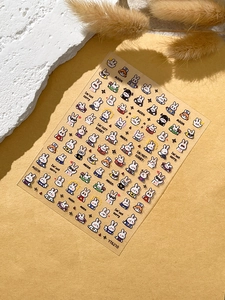 Close-up of cute cartoon white bunny nail art stickers with embossed textures on warm yellow background