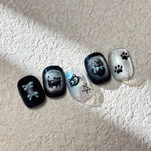 Cat eye press-on nails with black cat silhouettes and silver glitter star patterns