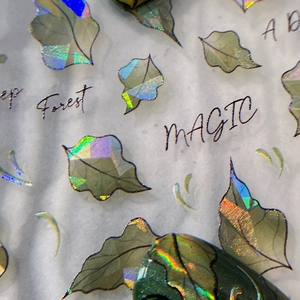Holographic leaf nail art stickers with laser finish and forest themed typography