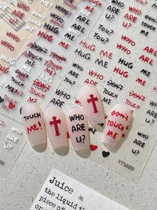 Detailed view of red and black relief letter nail art stickers with punk style slogans
