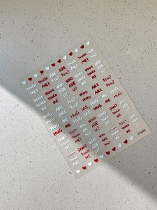 Macro shot of 3D embossed letter nail stickers in red and white with heart details