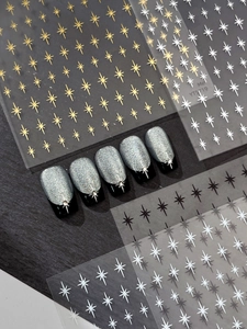 Detail of star-shaped nail art stickers in gold, silver, black, and white colors