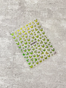 Detail of glittery green and yellow butterfly nail stickers with small rhinestone accents