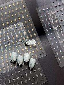 Macro shot of assorted starburst nail stickers with finished silver glitter art sample