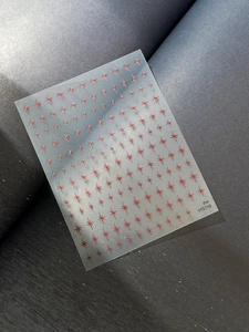 Macro detail of red star pattern nail art stickers on translucent matte backing paper