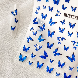 Blue gradient butterfly nail stickers with silver rhinestones on a clear backing sheet