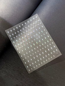 Macro detail of holographic star nail stickers with laser reflective effect on black background