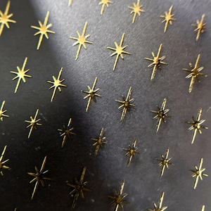 Sparkling gold starburst nail art stickers with minimalist 3D embossed metallic effect