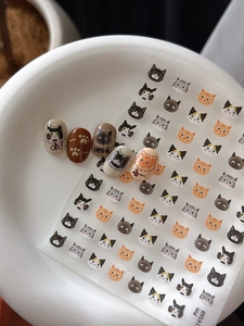 Macro view of cute cartoon cat nail art stickers and finished decorative fake nails