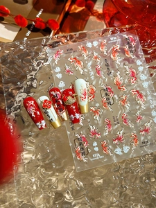 Detail of New Year nail stickers with koi fish and lucky charms on a glass tray