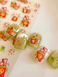 Macro view of Lunar New Year nail stickers with gold foil fortune symbols and red envelopes